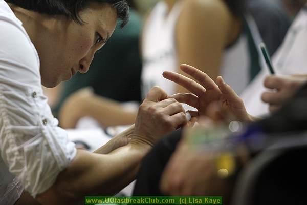 UO Athletic Trainer, Tori Noda, treats Lilley's jammed finger.